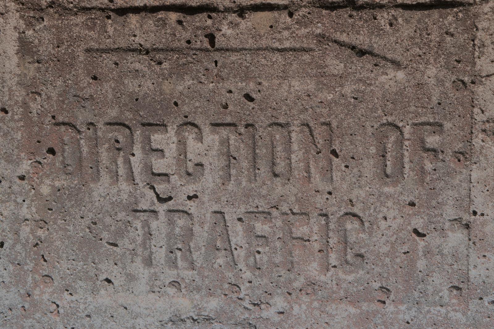 Photograph of a sign or marking out of context, left behind in an edgeland