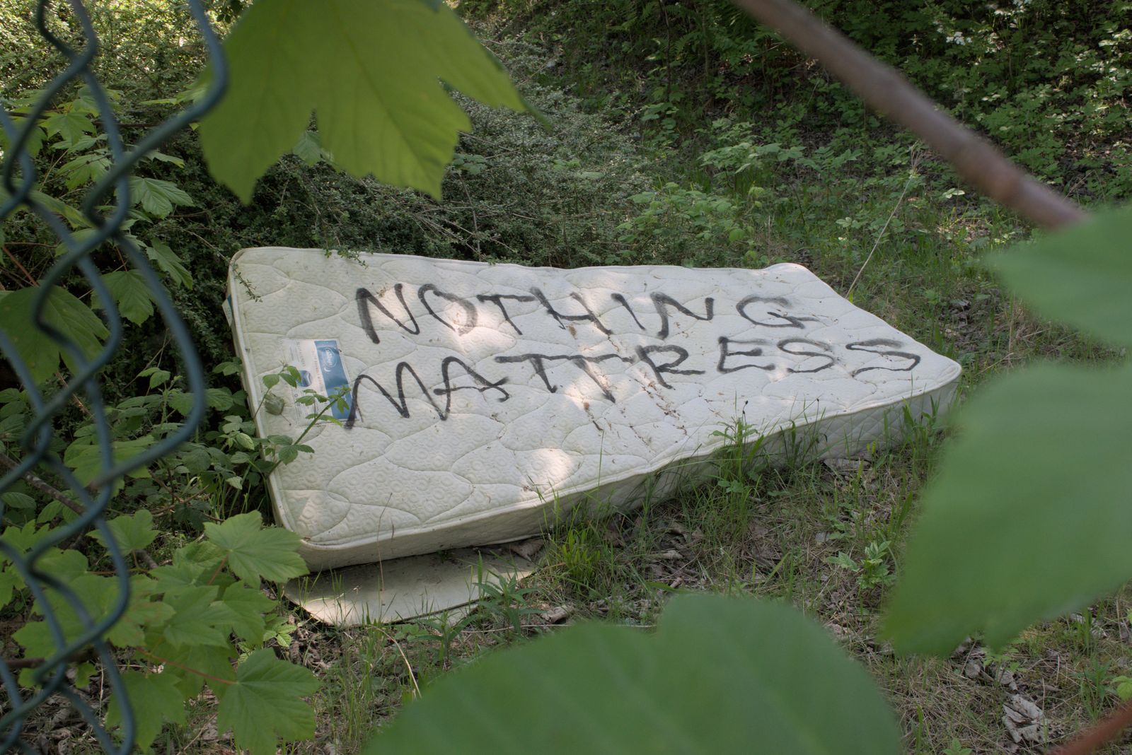 Photograph of a sign or marking out of context, left behind in an edgeland